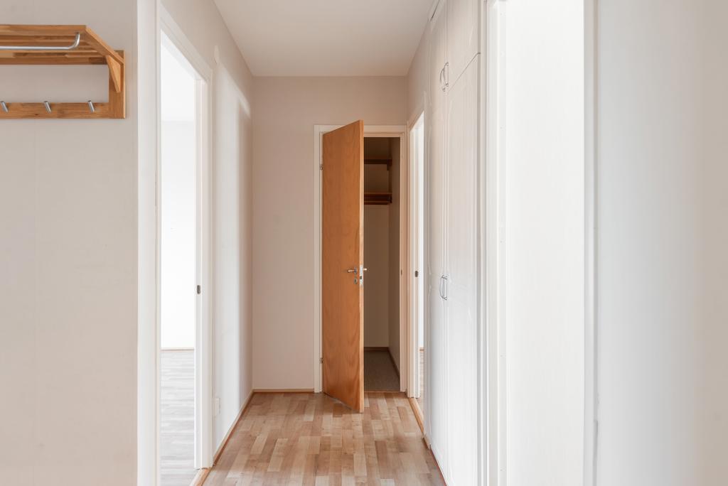 Central hall med kök till höger. Garderober längs väggen. Sovrum 2 längre bort till höger. Klädkammare rakt fram. Vardagsrum till vänster. 