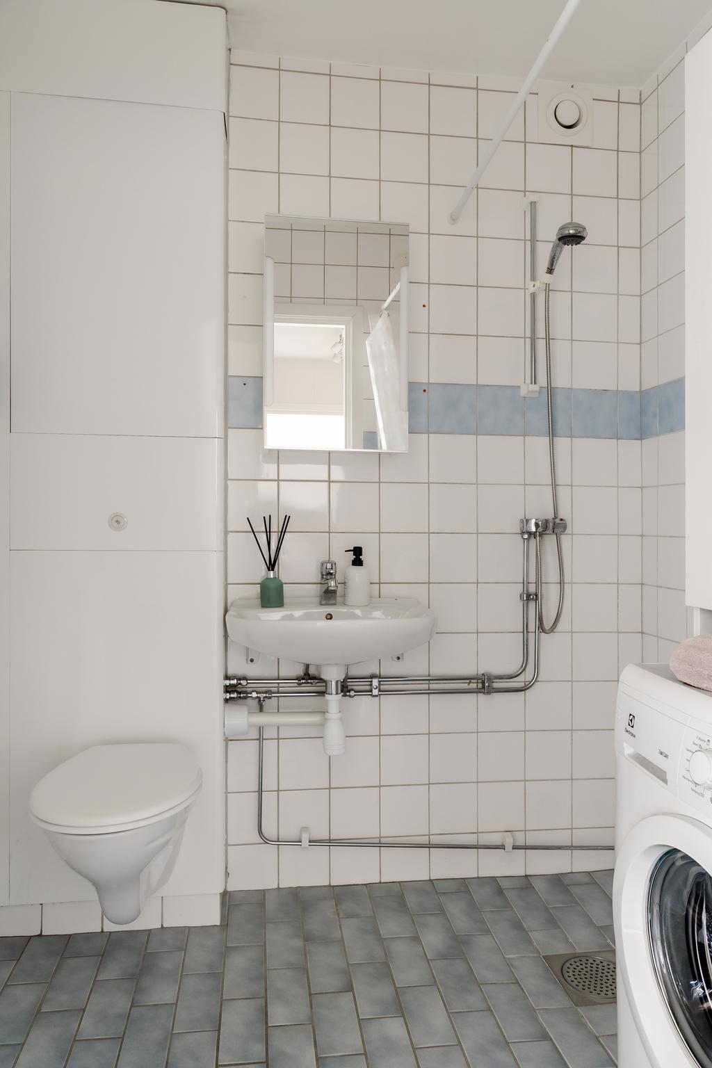 Helkaklat badrum med tvättmaskin