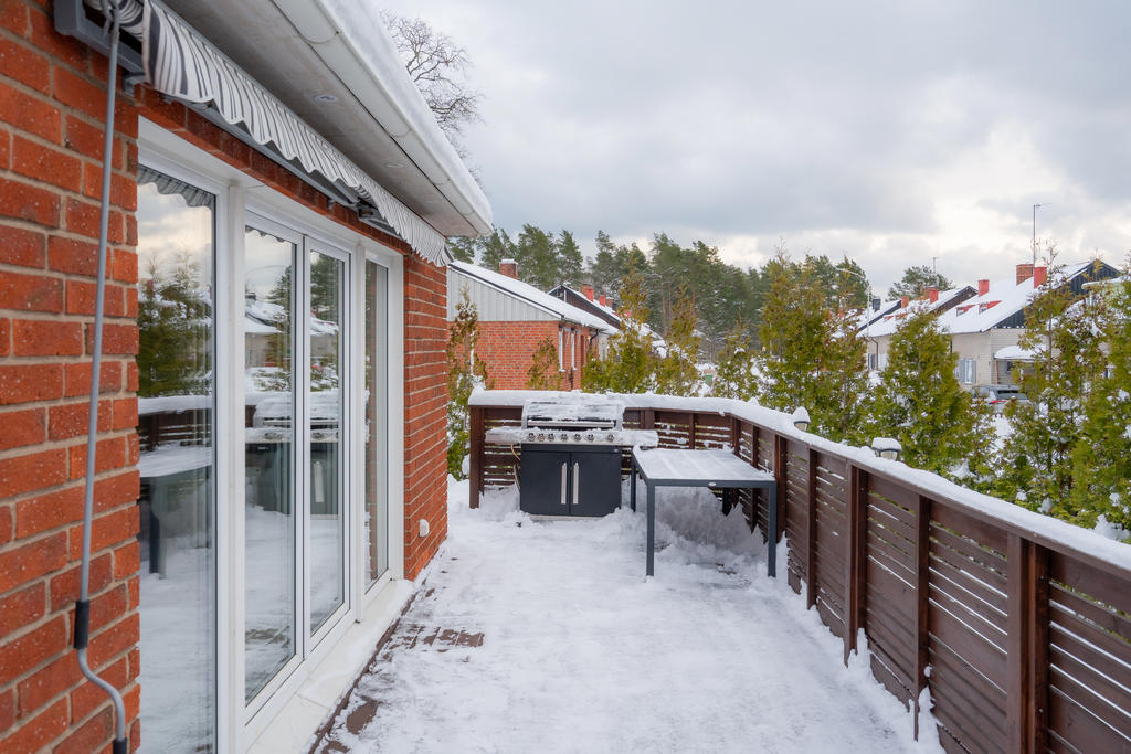 Uteplats på framsidan med nyare altandäck och staket. Generösa skjutdörrar ut från vardagsrum ger fantastisk öppenhet och tillgänglighet till uteplatsen.