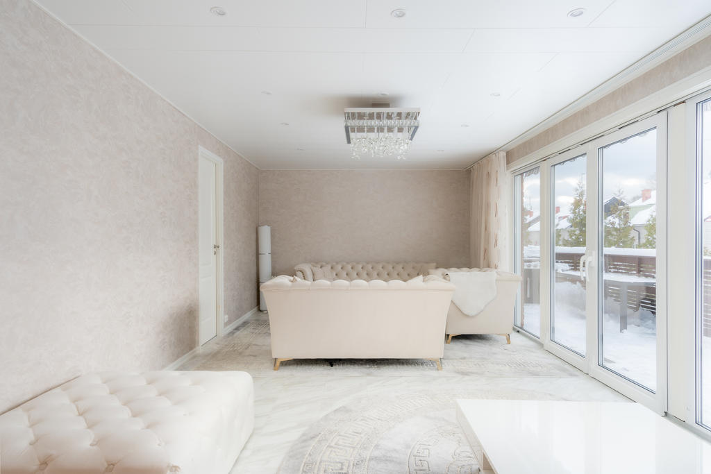 Ljust vardagsrum. Dimbara spotlights i taket. Generösa öppningsbara glaspartier ut till framsidan.