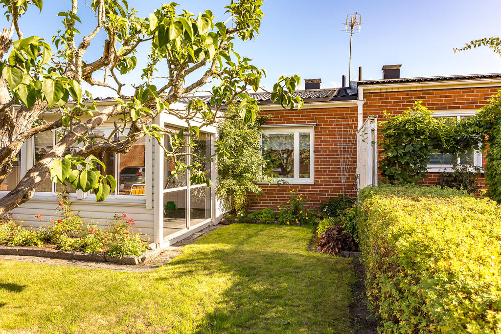 Framsidan av huset med syrenträdet och inglasat uterum 