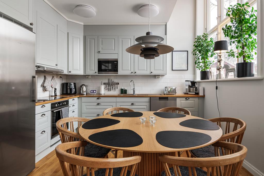 Köket i vackert lindblomsgrönt harmonierar fint med lägenhetens övriga material och färger.