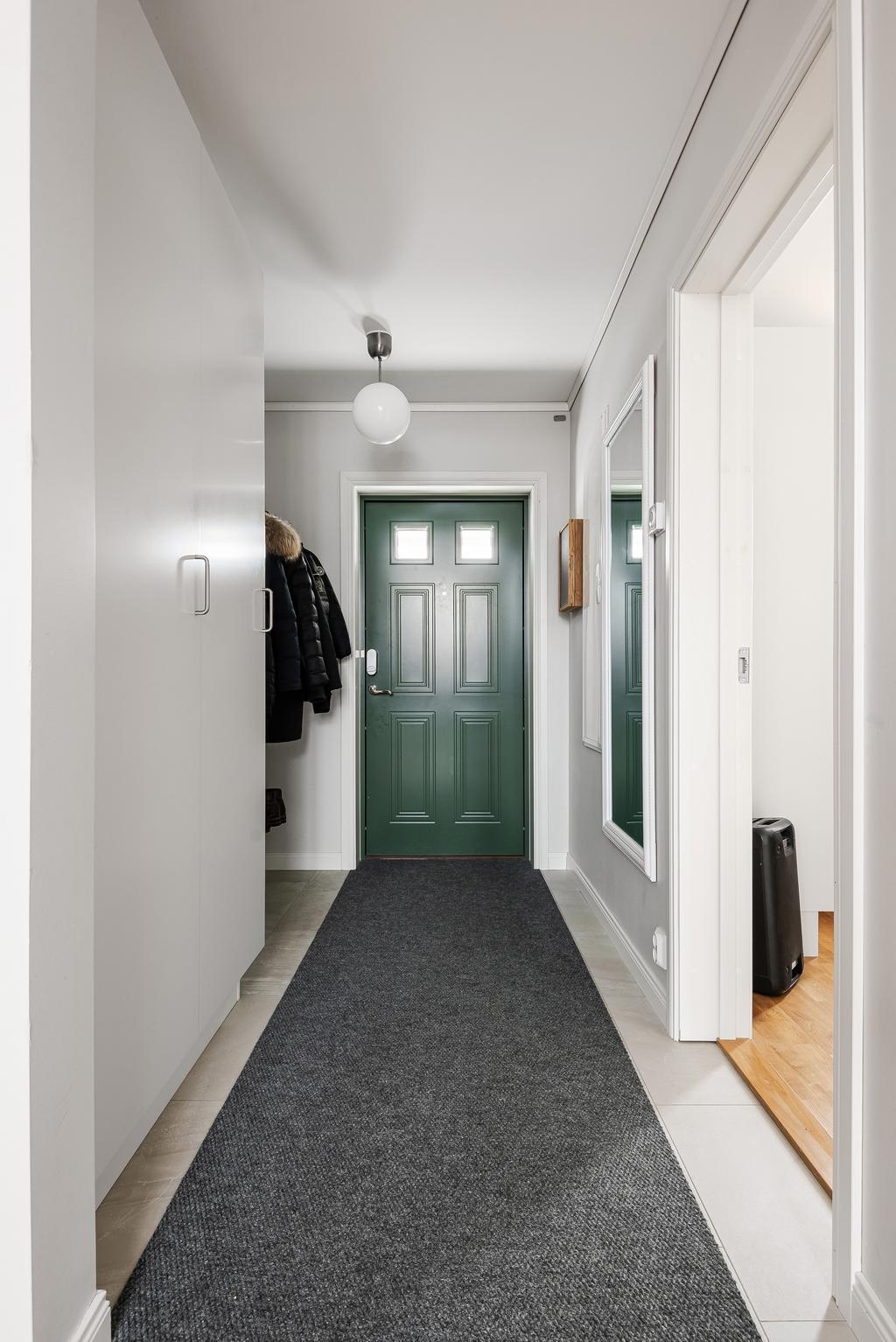 Vackert grön entrédörr välkomnar dig in i hallen!
