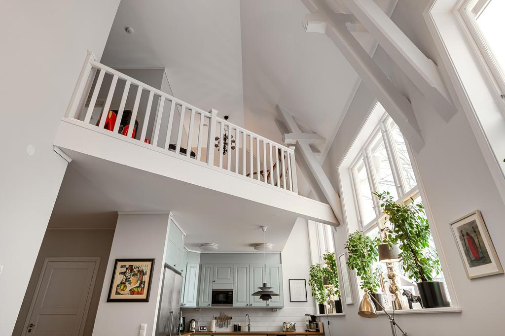 Varsamt renoverad och ombyggd lägenhet där man har bevarat byggnadens karaktär med bibehållen takhöjd och synliga takbjälkar.