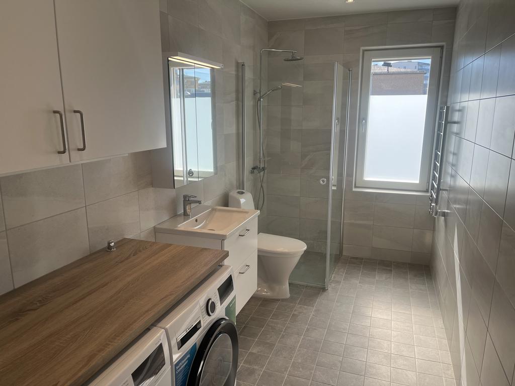 Helkaklat badrum med generösa  arbetsytor, bra duschplats och fönster 