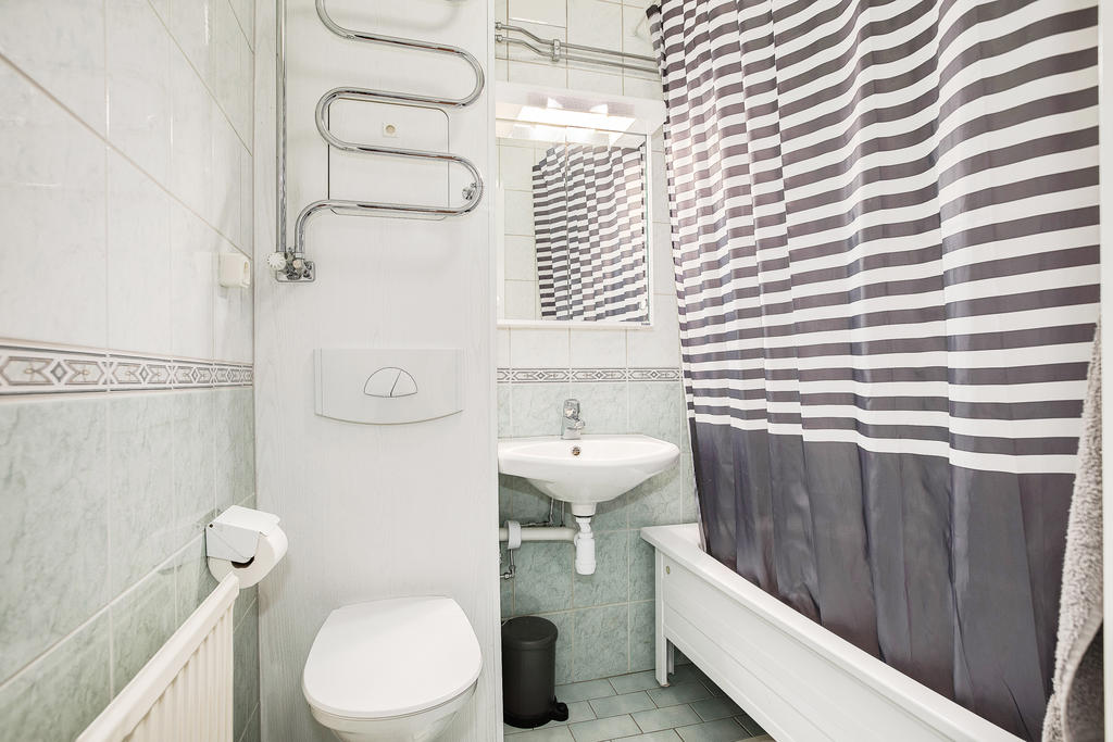 Helkaklat badrum med handdukstork, spegelskåp och badkar