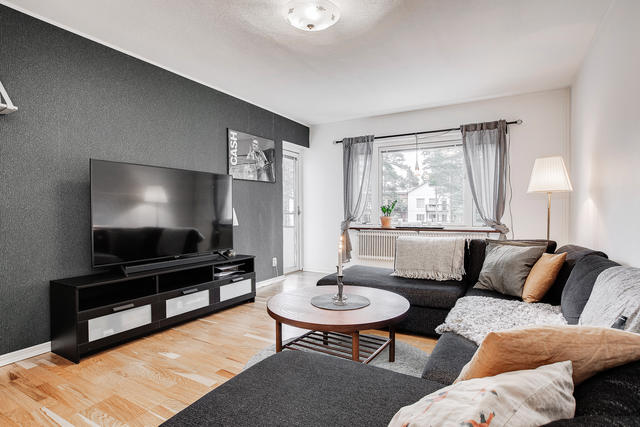 Vardagsrum med grön utsikt och balkong