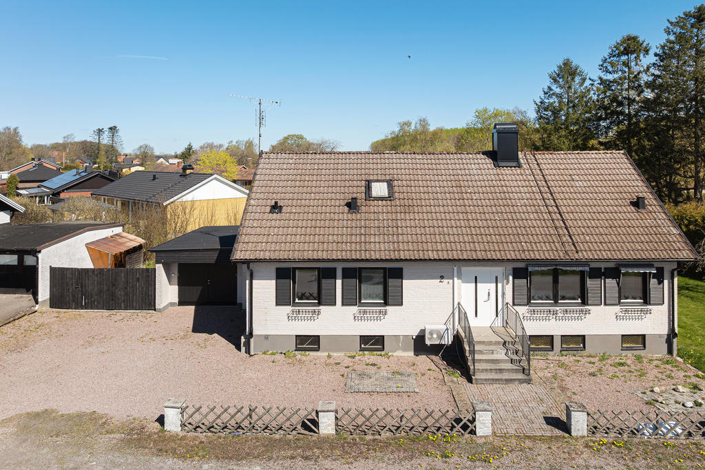 Entrésidan med stor uppfart och garage