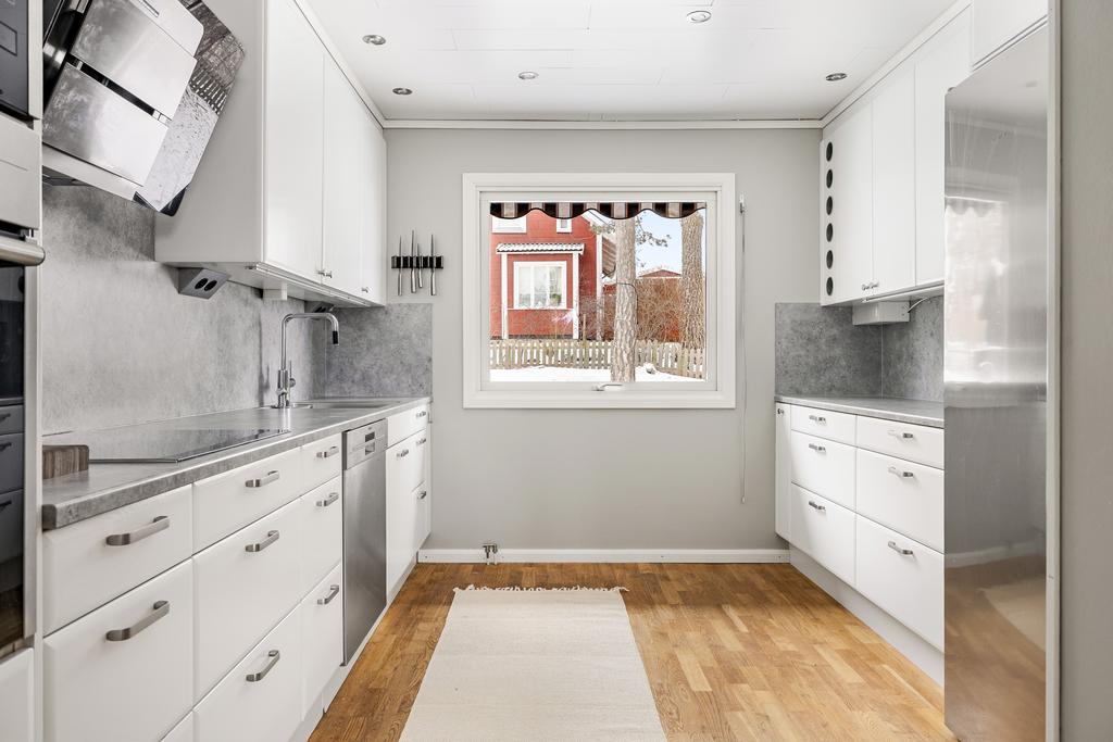 Fullutrustat arbetskök med gott om förvaringsmöjligheter och arbetsbytor