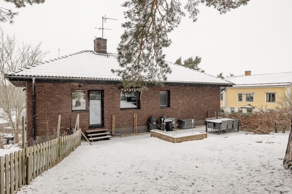 Baksidan med uteplats och gräsytor.