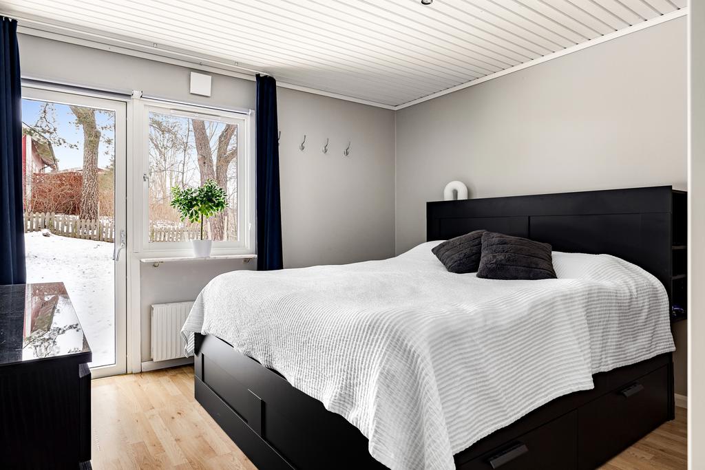 Sovrum 1 med 2 inbyggda garderober och utgång till trädgård och uteplast