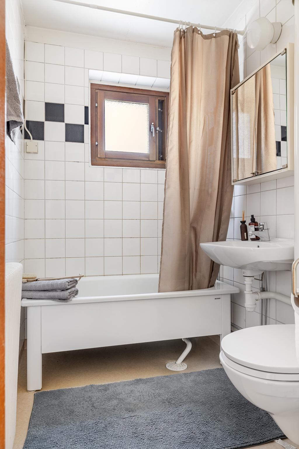 Ljust badrum med plats för badkar