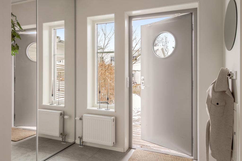 Ljus entré med plats för avhängning och fint ljusinsläpp från sidofönster.