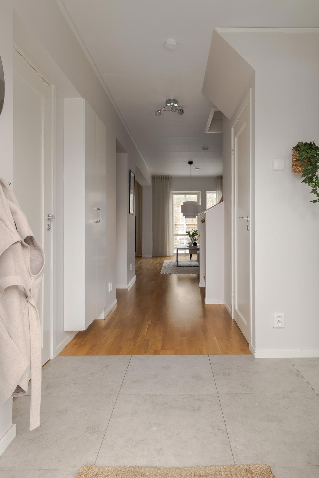 Hall med utblick genom bostaden och vidare mot de sociala ytorna.