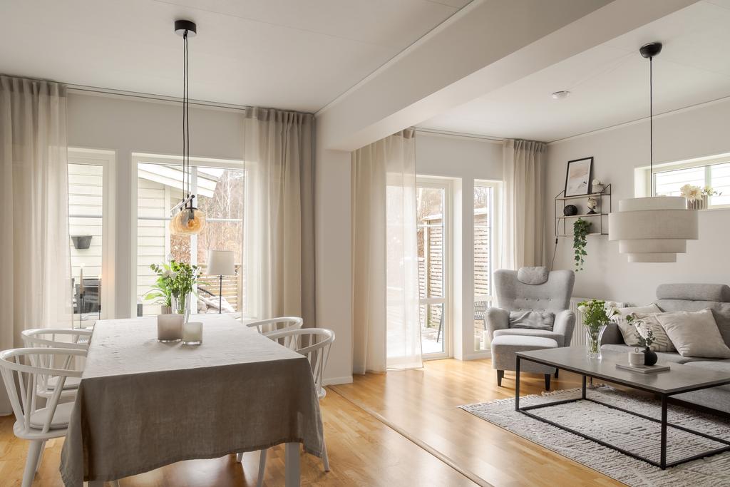 Matplats och vardagsrum i öppen disposition med fönsterpartier mot altanen.