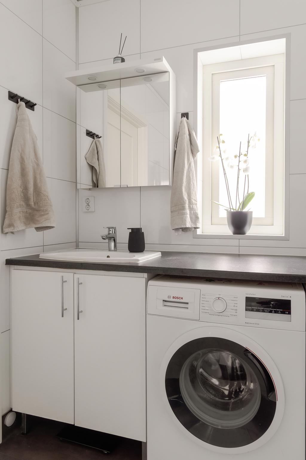 Badrum på entréplan med dusch samt praktisk tvättdel. Väggarna är klädda med våtrumsskivor och rummet har en funktionell och lättskött utformning.