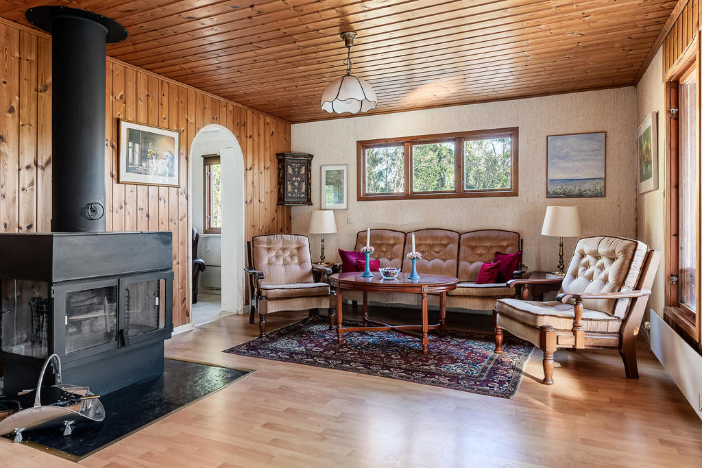 Vardagsrum med braskamin och ett litet rum innanför