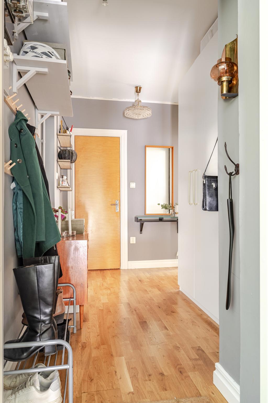 Hall med ingång till duschrum och vardagsrum.