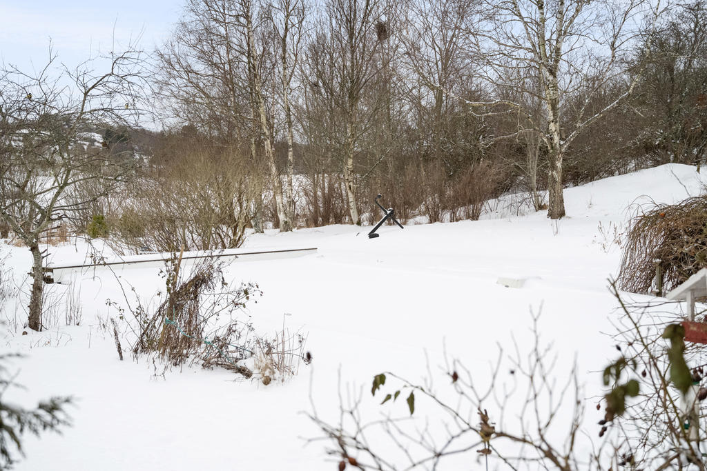 Under snön väntar poolen på vårens värmande strålar.