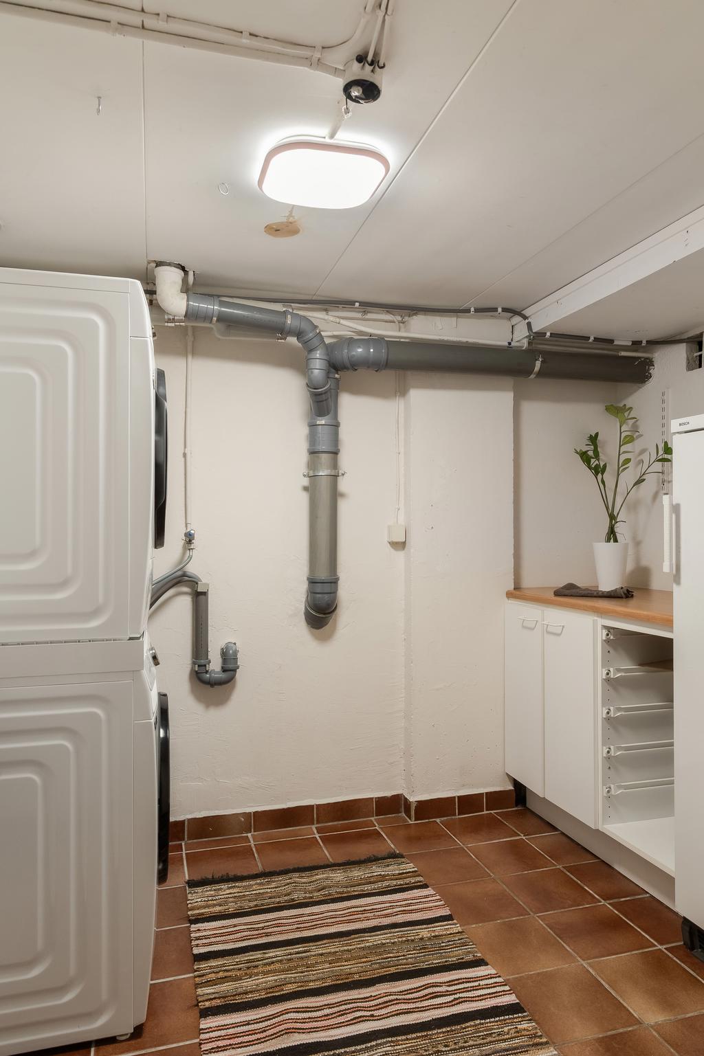 Praktisk tvättstuga med arbetsyta och förvaring.