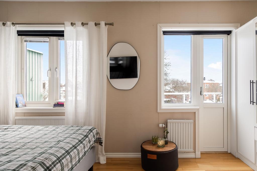 Sovrum med fönster och utsikt mot området.