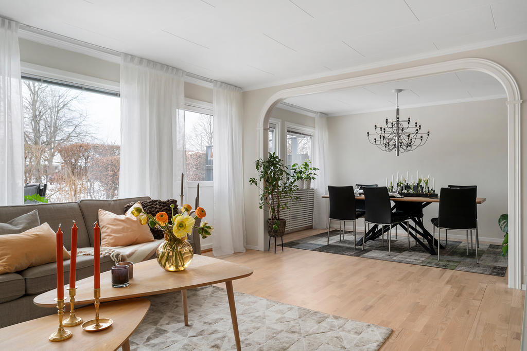 Vardagsrum med stora fönsterpartier som ger fint ljus och rymd åt rummet