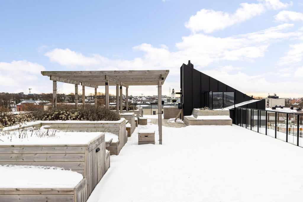 Gemensam takterrass med många sittplatser och utekök