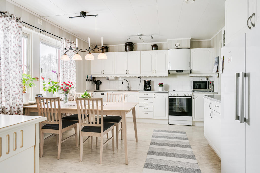 Ljust och praktiskt kök med plats för mindre matgrupp. 