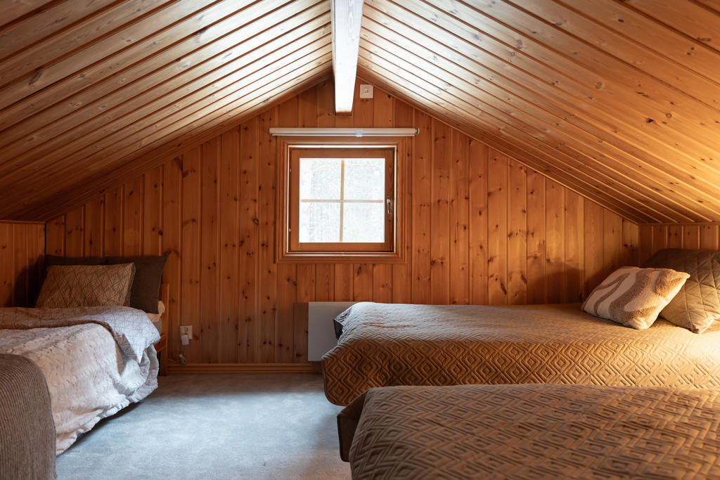 På övreplan finner du ett sovrum med heltäckningsmatta och lats för tre sängar.