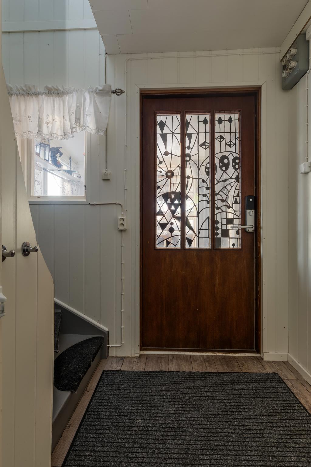 Hall med avhängningsplats och förråd under trapp.