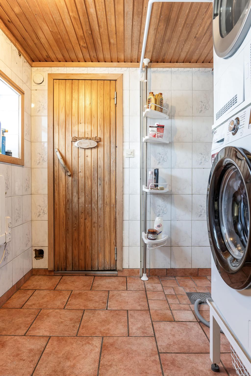 Tvättstuga med dusch och bastu i uthus.