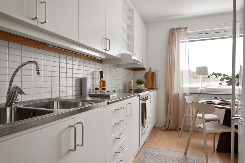 Kök med vita luckor och gott om förvaring.