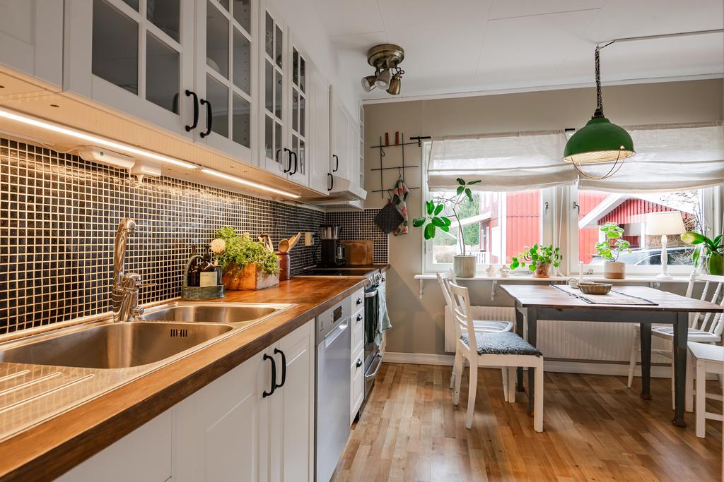 Ljus inredning, bänkskiva i trä och mörk mosaik till stänkskydd. 