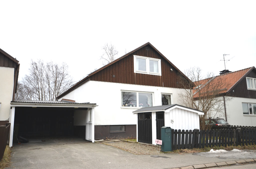 Entrèsidan med carport och garage