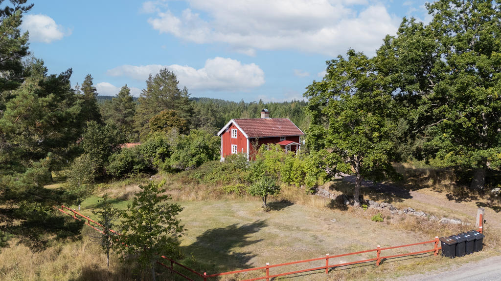 Här erbjuds ett rött torp med vita knutar på väl tilltagen trädgårdstomt om 3 526 m²