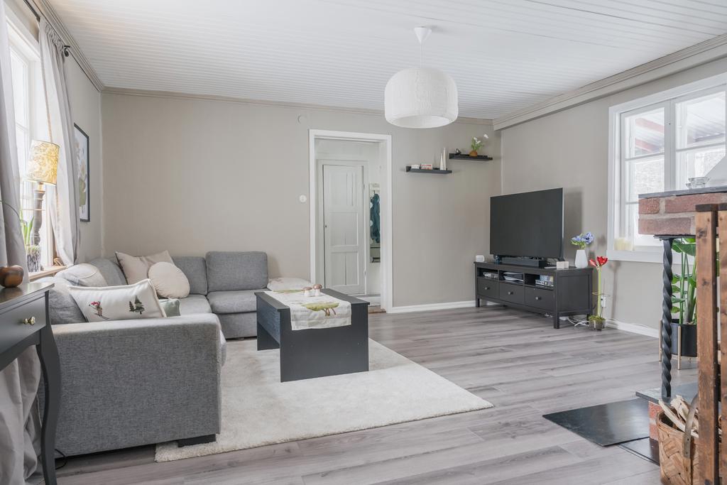 Från vardagsrummet finns en naturlig vy mot entrén, vilket bidrar till en öppen och välkomnande känsla.