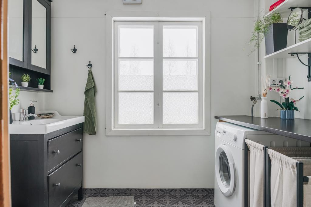 Badrum med praktisk tvättdel som underlättar vardagen. Här finns tvättmaskin, arbetsyta samt bra förvaring i en ljus och funktionell miljö.
