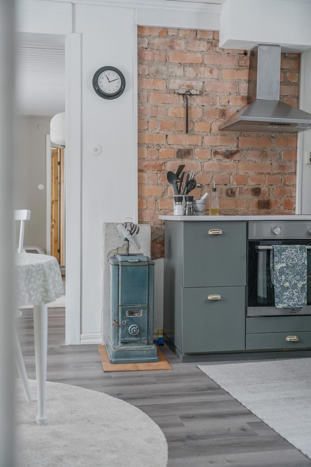Charmig kamin som ger köket både karaktär och extra värmekälla.