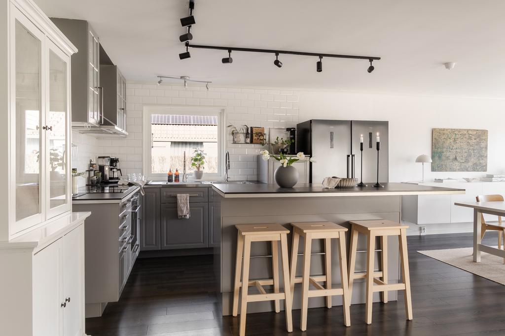 Köket är både praktiskt och snyggt med mörkare skåpluckor som kombineras med vitt kakel som stänkskydd 