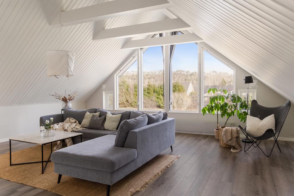 Stora fönster som vetter mot altan och grönområde