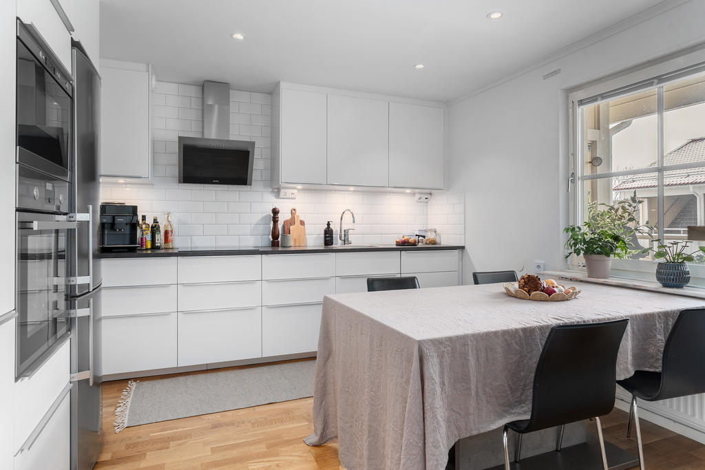 Stilrent renoverat kök med rostfria vitvaror