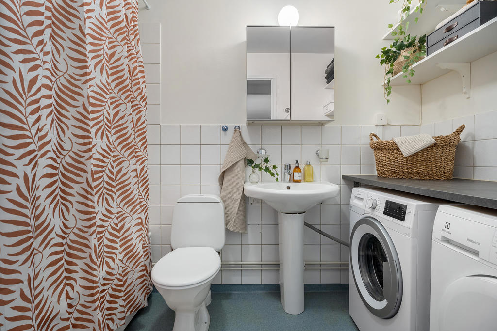 Badrum med tvättutrustning och badkar