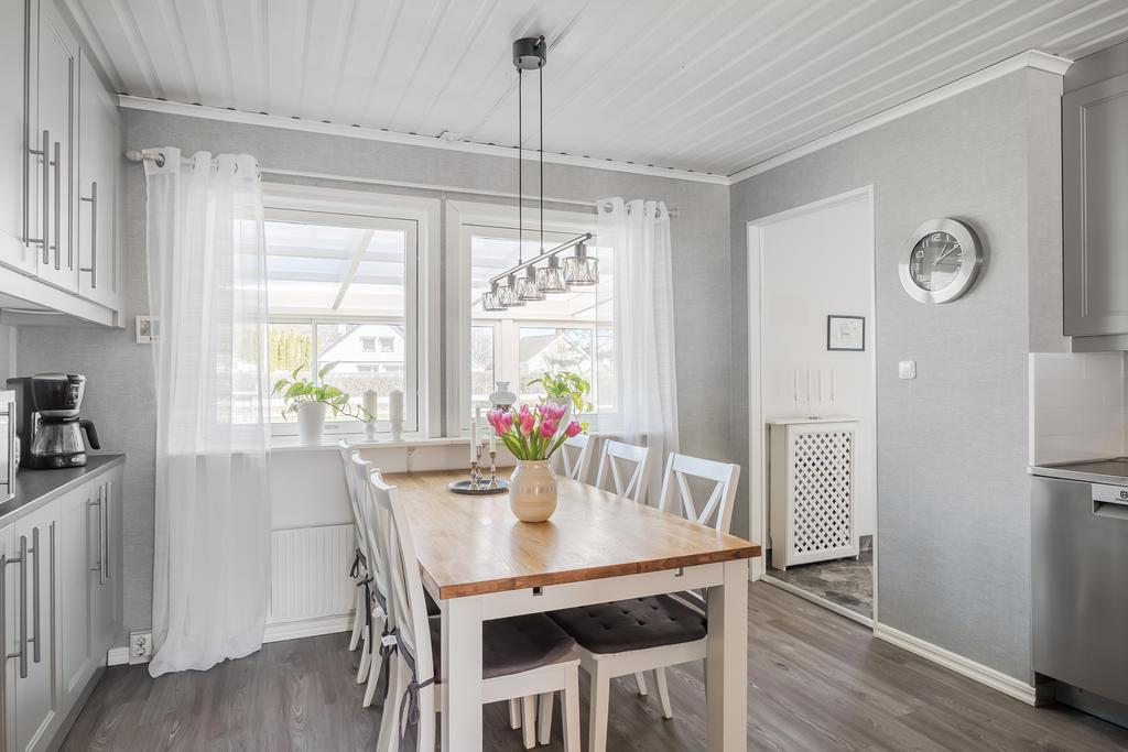 Fint kök med utsikt mot uterum och trädgård.