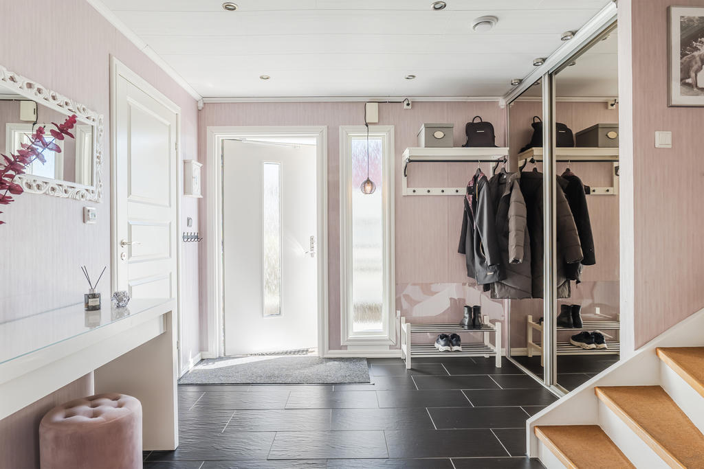 Välkommen in till en rymlig hall med mycket förvaring.