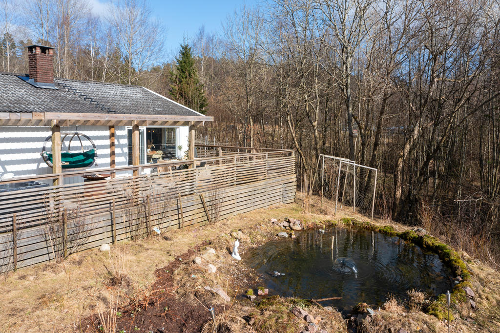 På husets baksidan finns en damm med fontän och vattenfall.