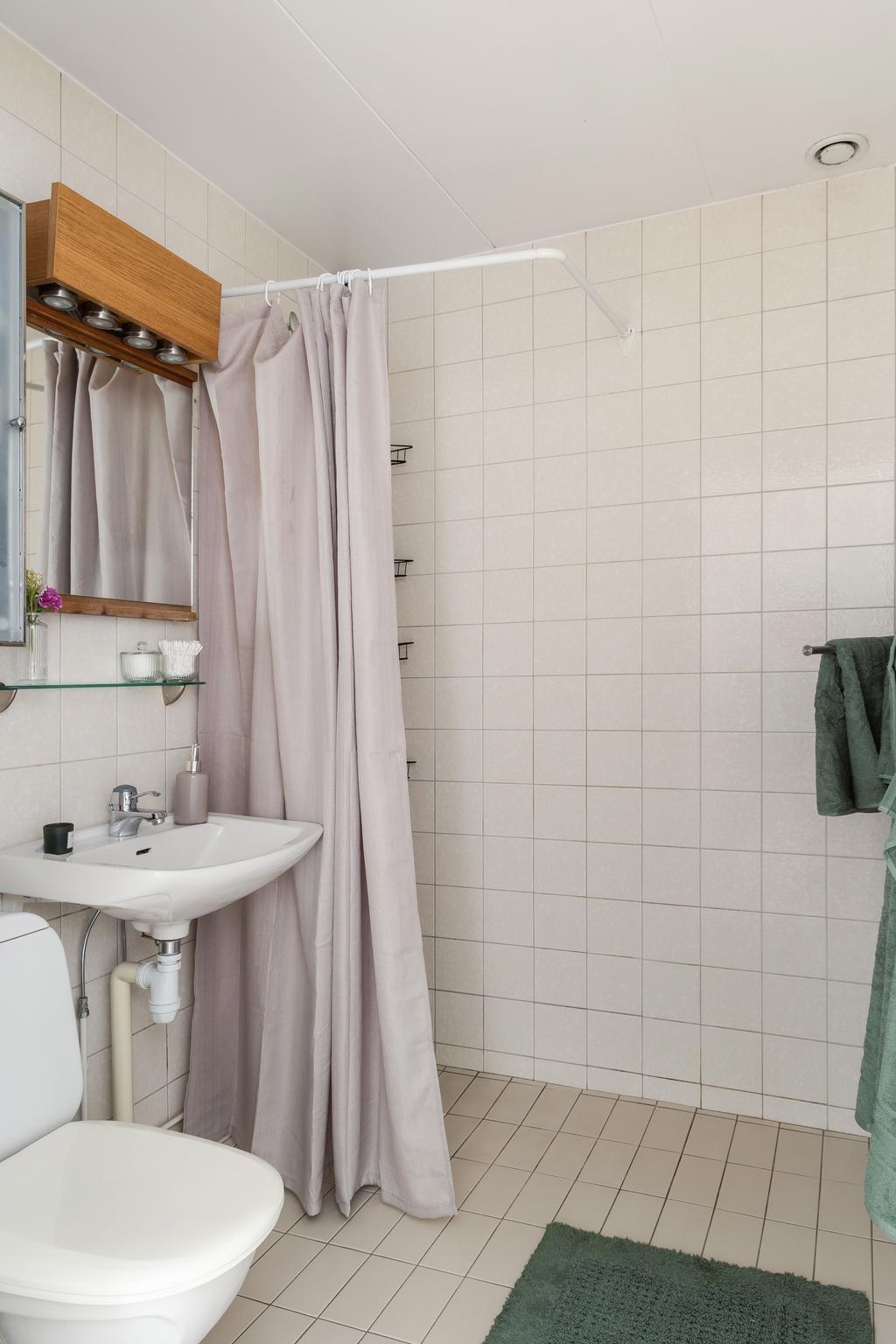 Det helkaklade badrummet nås via entrén och ligger intill sovrummet 