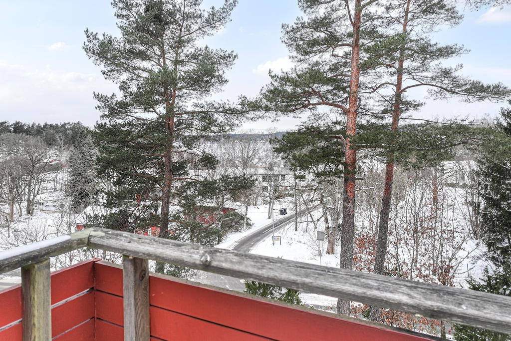 Balkong ut mot tallar och sjön mjörn.
