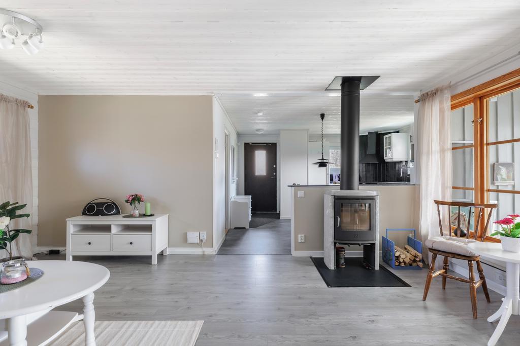 Ljust och rymligt vardagsrum med mysig täljstenskamin.