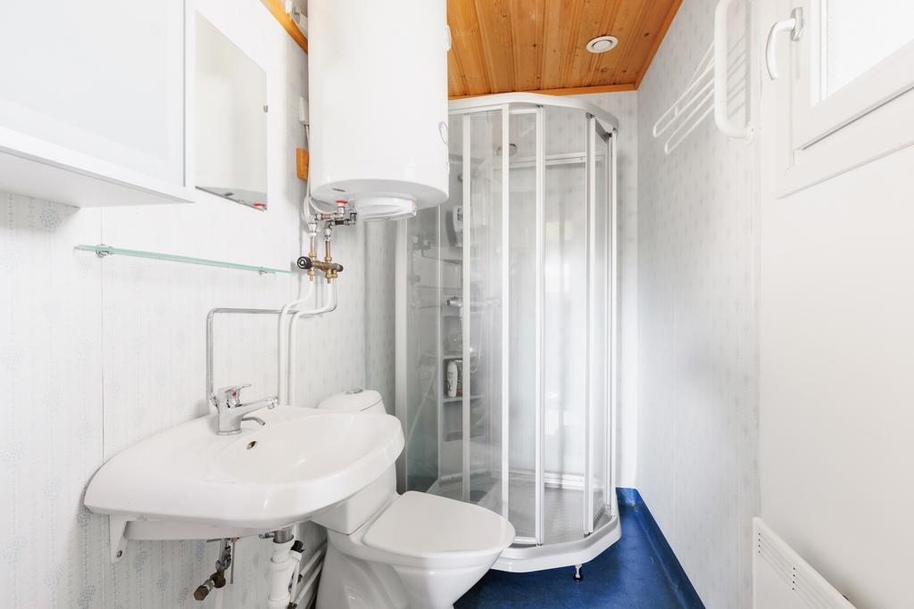 Badrum utrustat med wc, handfat, duschkabin och varmvattensberedare.