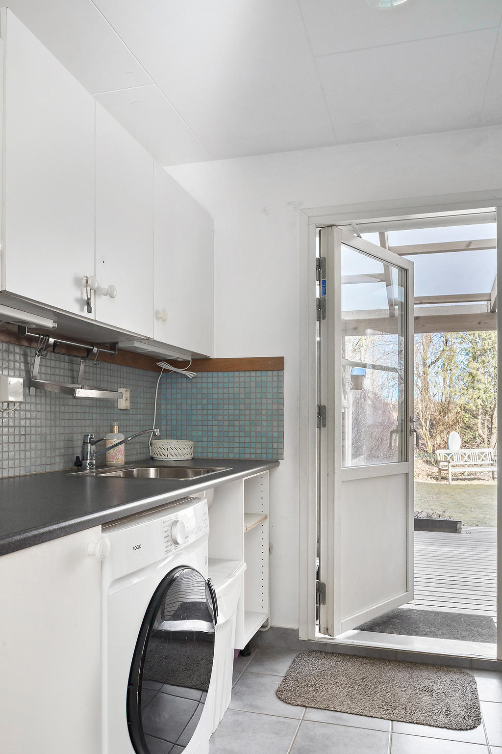 Tvättstuga med utgång till uteplats i öster